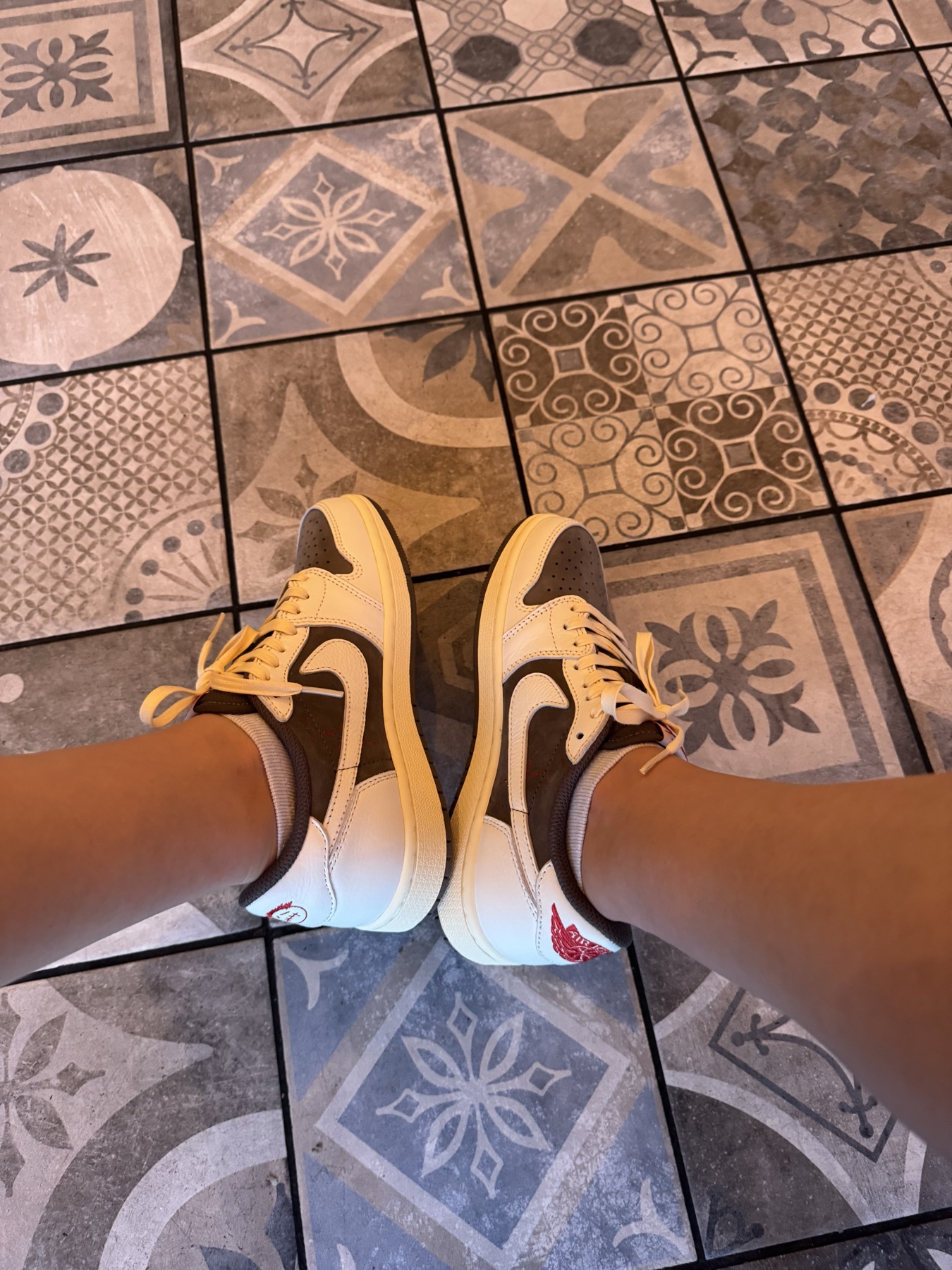 Reverse Mocha Jordans worn on a patterned tile floor